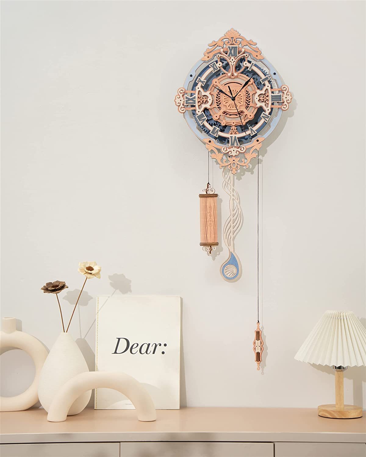 Decorative wall clock with pendulum on a shelf with minimal decor